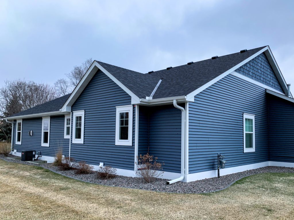 new windows and siding on a blue house