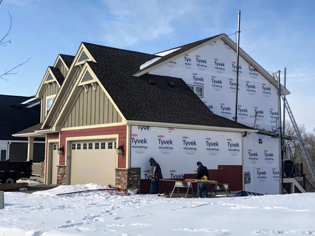 new construction home in the process of having siding installed